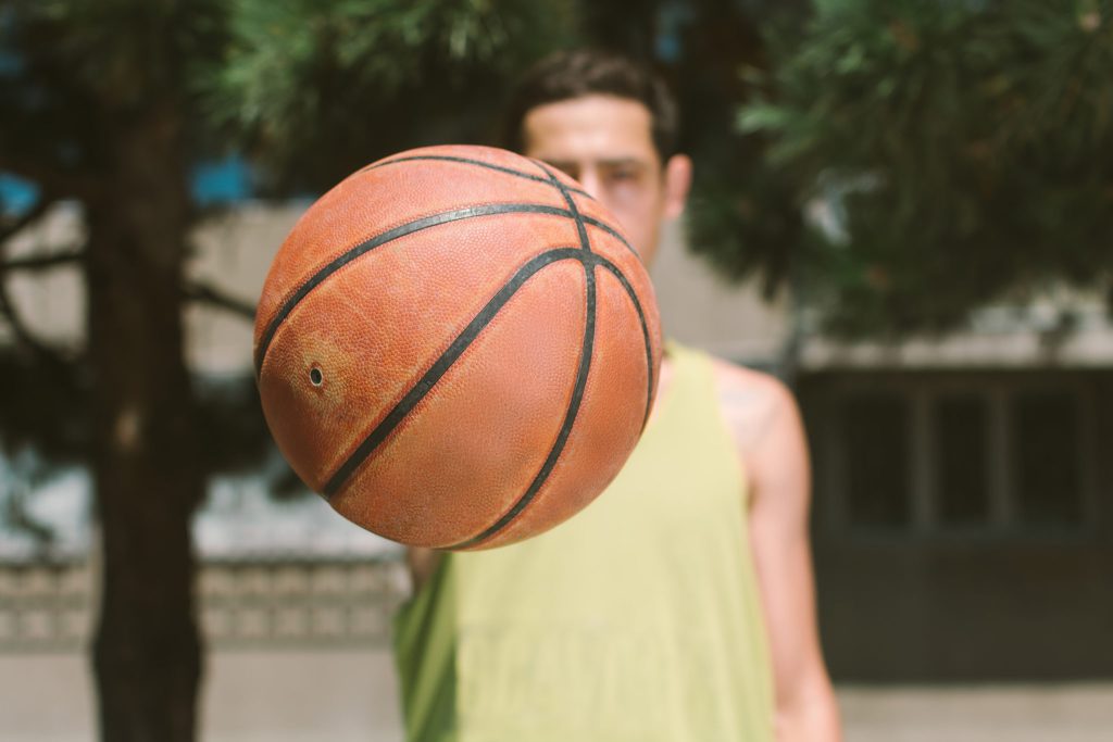 Man holding basketball on outdoor basketball court