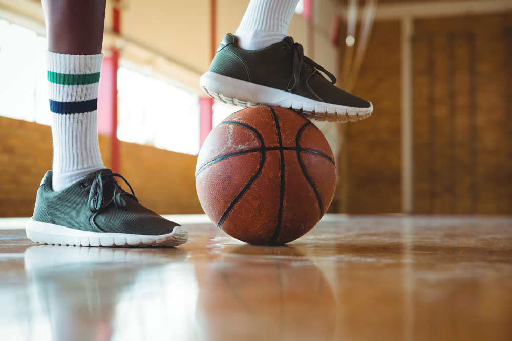Person with green shoes standing on basketball