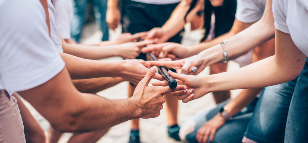 Team building activity of people holding up a rod