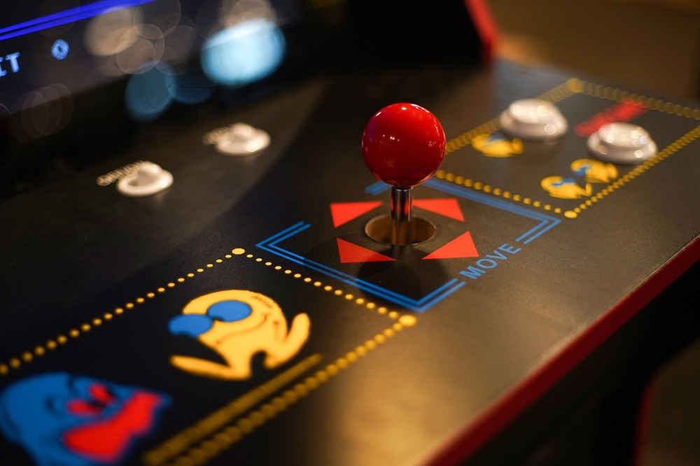 A close-up of a Pac-Man arcade game joystick