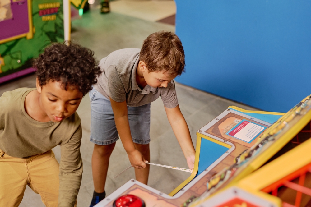 Two boys playing a ticket redemption game at an arcade